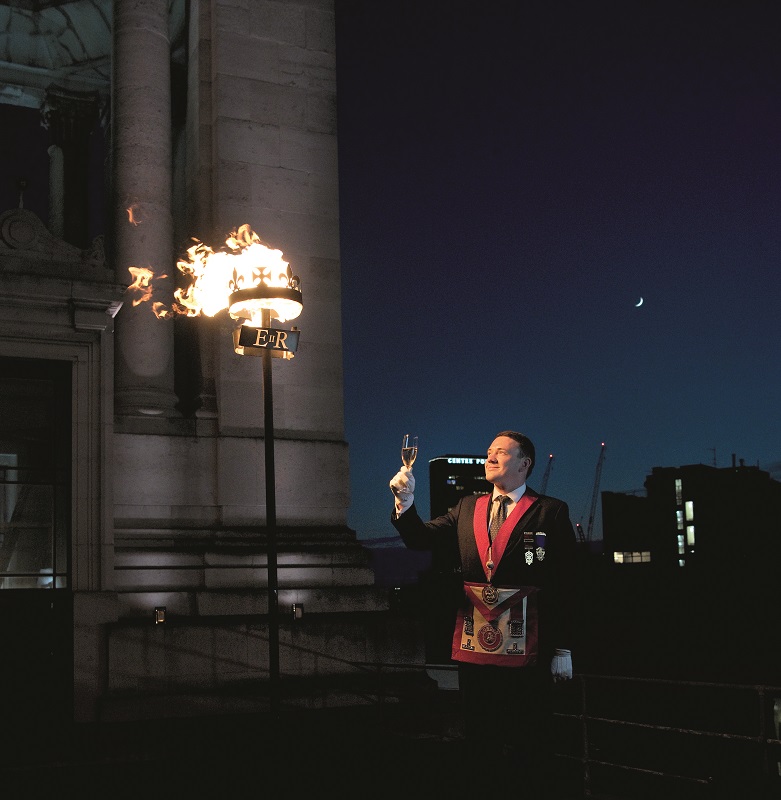 Freemason Dr Jake Mossom lights and toasts the Jubilee beacon at Freemasons' Hall on 2 June