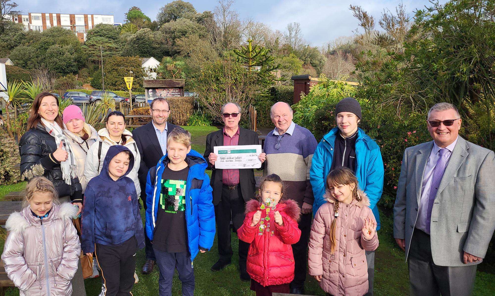 Dr David Harwood and Simon Chapman were joined for the presentation by some of those they are supporting - Svitlana, Nataliia, Lana, Sophia, Tim, Gleb, Mariia, Karina and Denys, the children enjoying a day out in the Torquay winter sunshine.