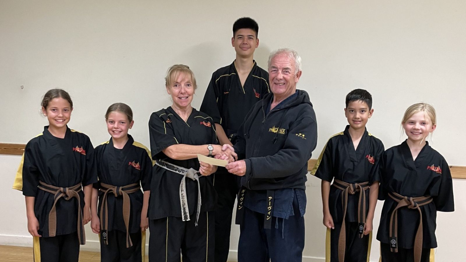 Sensei Gavin Irvine presents a cheque for £800 to fellow members of Phoenix Karate Club