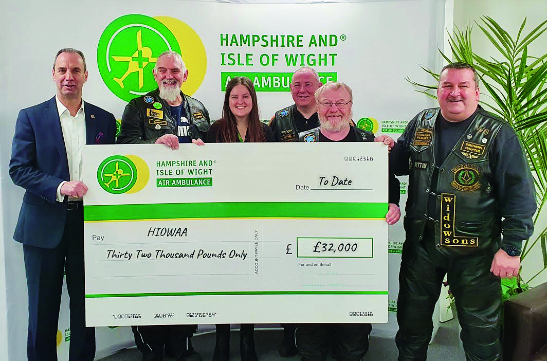 A group of people holding an oversized cheque and smiling