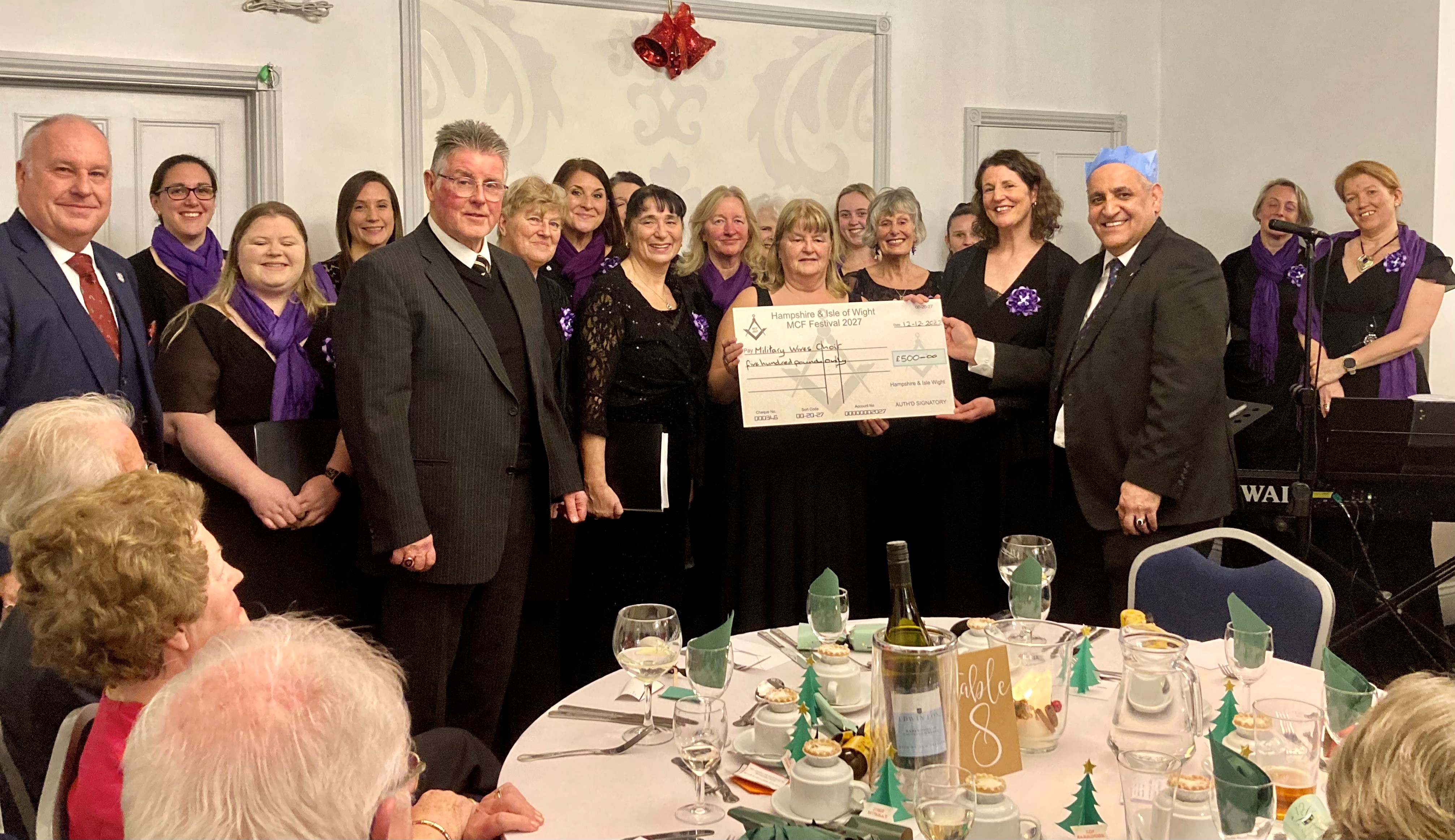 A group of people holding an oversized cheque and smiling to the camera