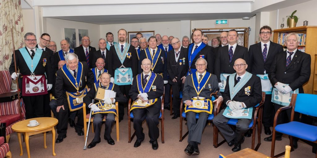 Members of the lodge sit in the homes day room in full regalia