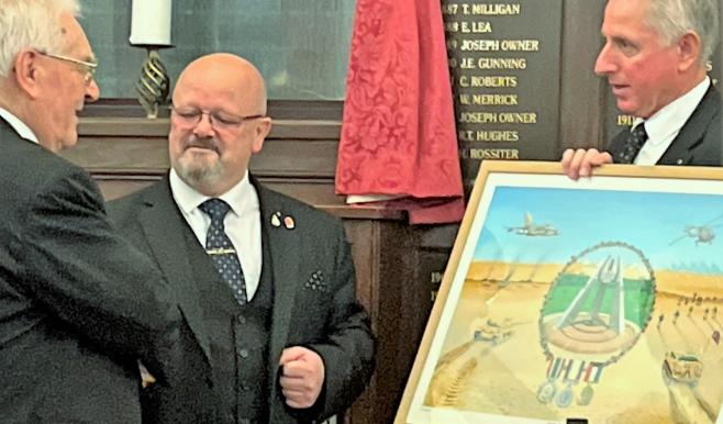 Three men, two shaking hands and the other is holding a painting