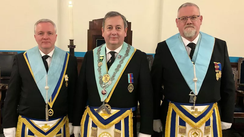 Three Freemasons in full regalia.