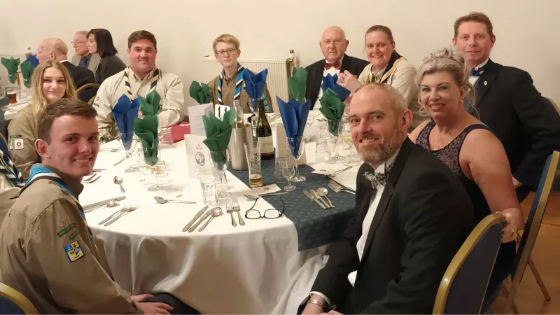  Martin Dennison (far right) sits with the Adventure Scouts at dinner.	